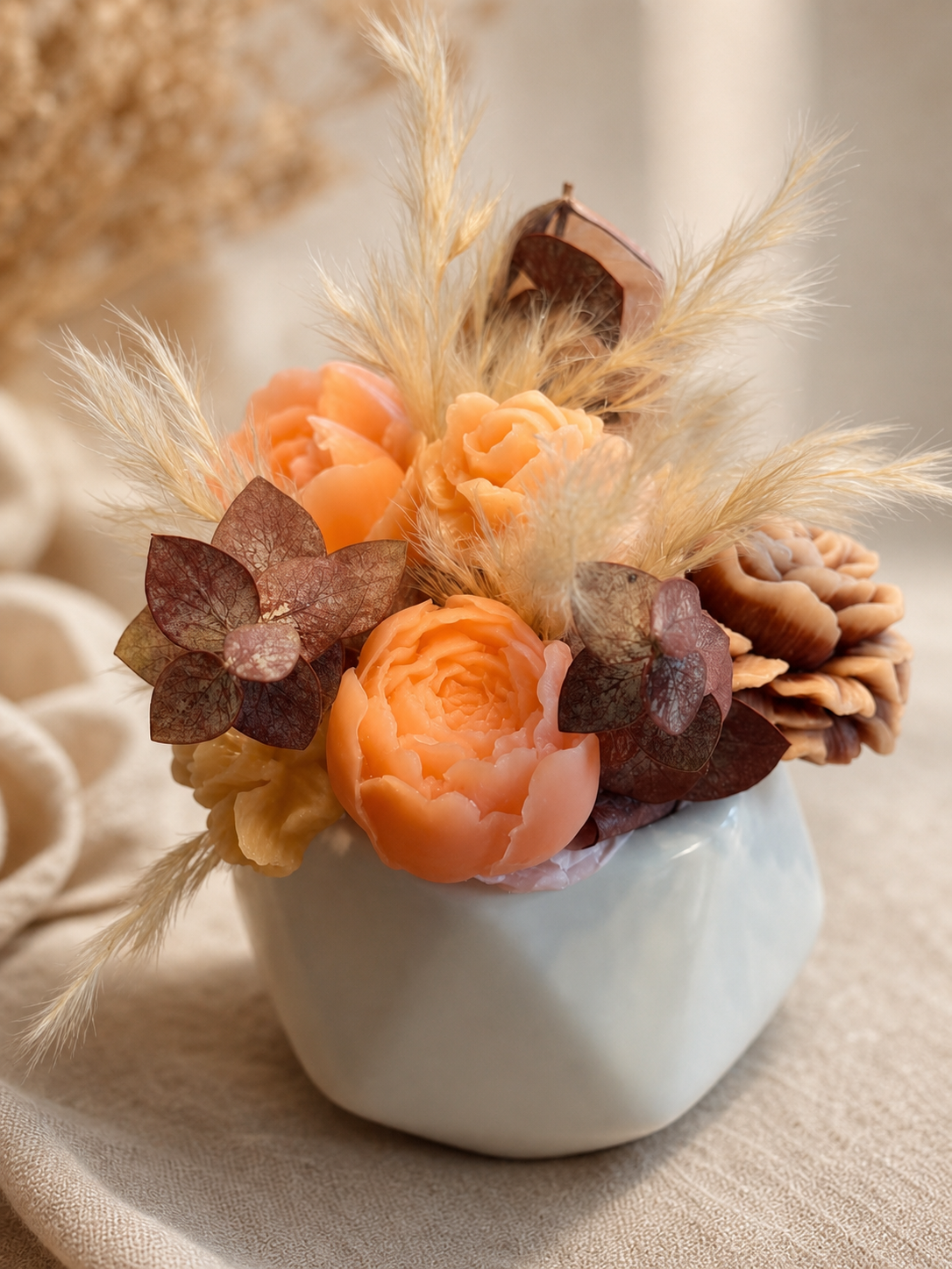 Peach scented wax floral arrangement with pampas accents in a petite ceramic vase